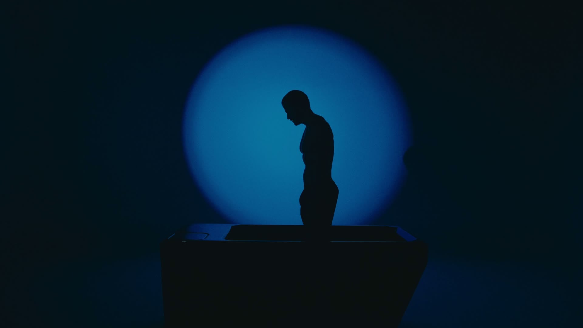 Silueta de una persona junto a una MF ONE, con luz azul de fondo